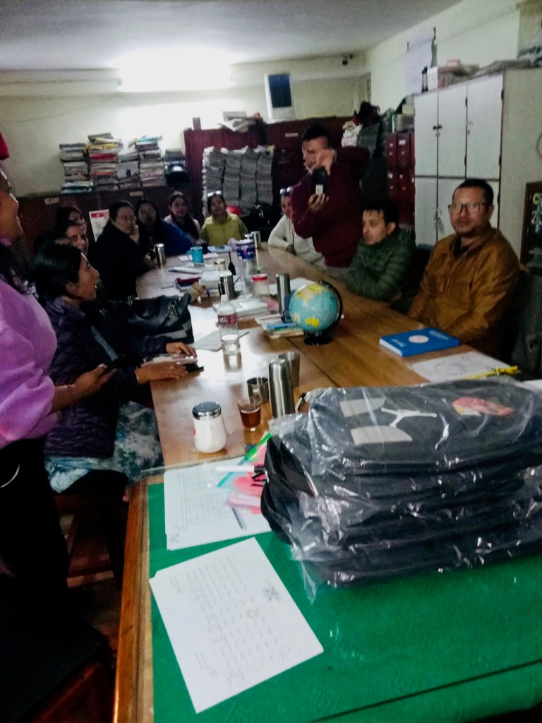 Children and adults gathered around a table with water bottles and school supplies